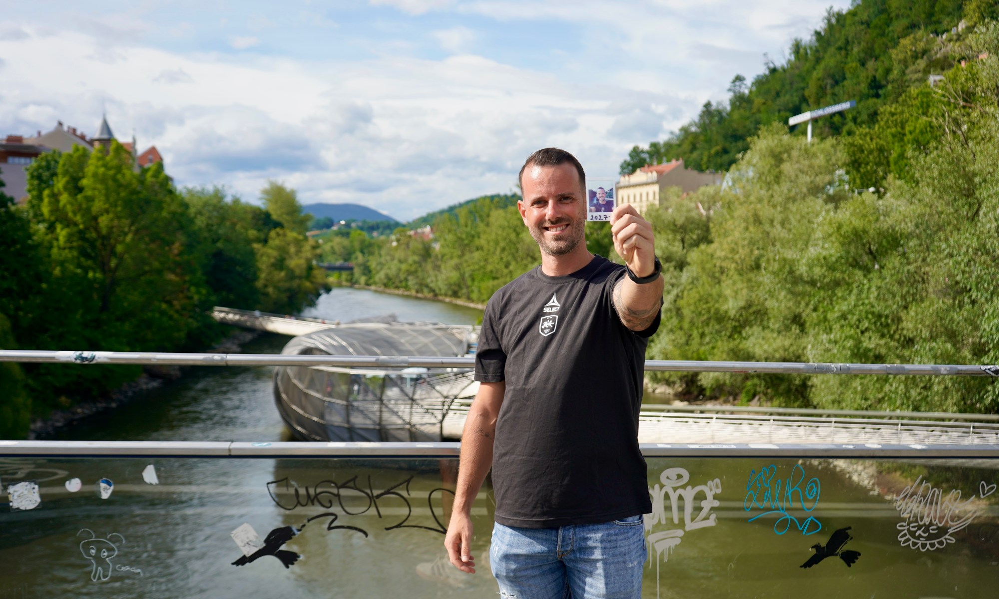 Mann mit Foto vor Murinsel in Graz